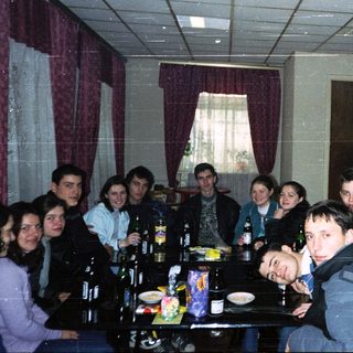 Group of people gathered indoors for a casual meal or gathering.