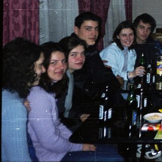 Group of people gathered indoors for a casual meal or gathering.