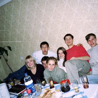 Group of friends posing indoors at a table.