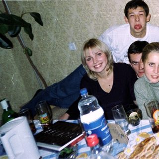 Group of friends posing indoors at a table.
