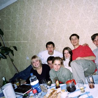 Group of friends posing indoors at a table.