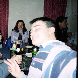 Group of people socializing indoors with drinks.