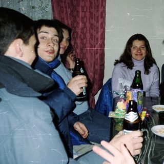 Group of people socializing indoors with drinks.