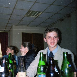 Group of people holding beer bottles indoors.