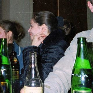 Group of people holding beer bottles indoors.