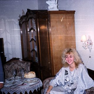 Woman sitting on vintage bed in classic interior.