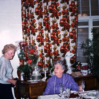 Two elderly women enjoying a festive meal together.