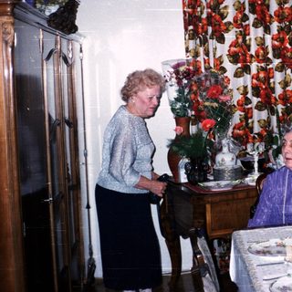 Two elderly women enjoying a festive meal together.