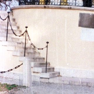 Two people standing on a raised observation platform in light rain.