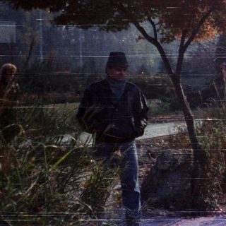 People walking in autumn park near water.