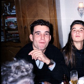 Three people dressed formally at an indoor dinner event.