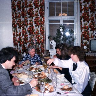 Family gathering enjoying holiday meal indoors.