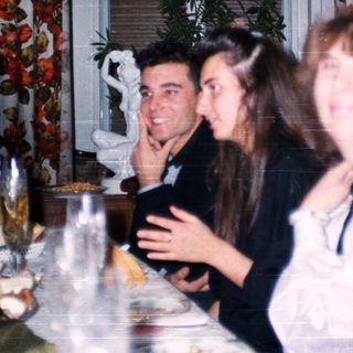 Family gathering enjoying meal indoors with vintage decor.