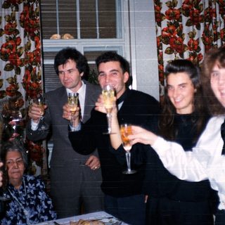 Group celebrating indoors with champagne toasts.