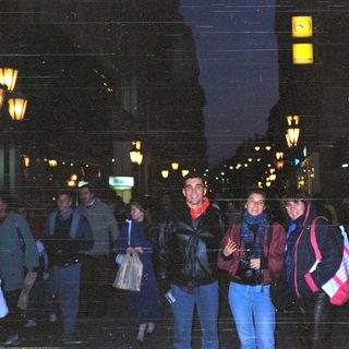 People posing together at night in city.