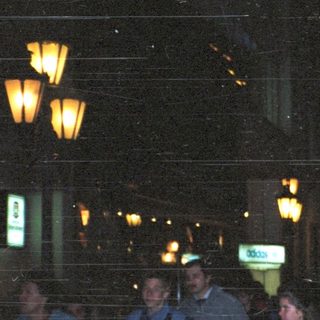 People posing together at night in city.