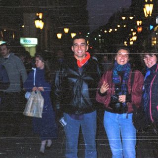 People posing together at night in city.
