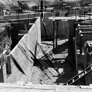Construction site showing a concrete wall and excavation.