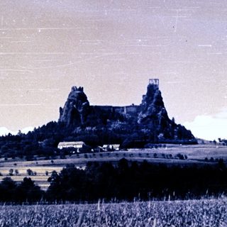 Ruins of a castle sit atop a grassy hill.