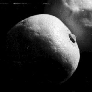 Two lemons are illuminated in a dark space.