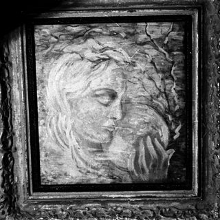 Framed portrait of a woman with hand near face.