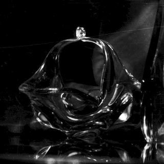 Here's a brief summary of the image: Black sculptural forms with reflective surfaces in a dark setting.