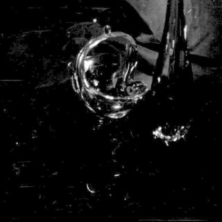 Broken glass and dark liquid on a dark surface.