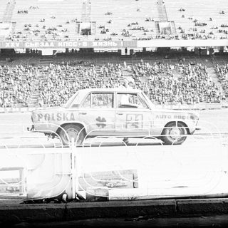 Vintage car rally takes place in a large stadium.
