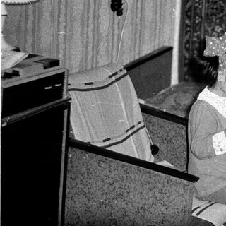 Girl sits reading a book in a vintage room.