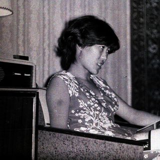 Woman reading a magazine while seated indoors.