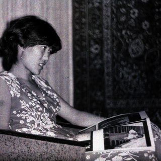 Woman reading a magazine while seated indoors.