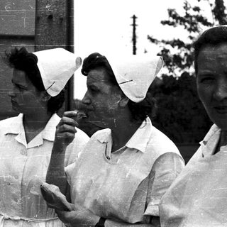 Three women in nurse uniforms outdoors, likely at a hospital.