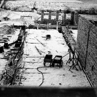 Construction site with brickwork and equipment in snow.