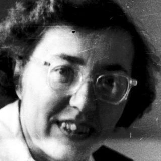 Black-and-white portrait of an older woman smiling.