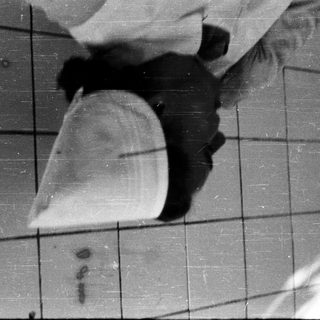 Person wearing large white hooded cape indoors.