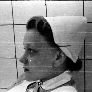Nurse in traditional cap and uniform.