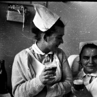 Two nurses sharing a light moment indoors.