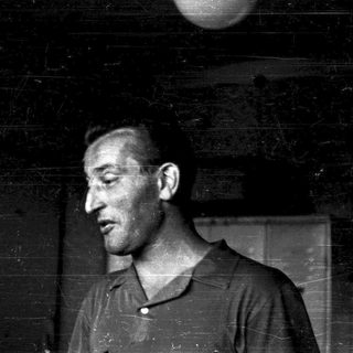 Black-and-white portrait of a man indoors.