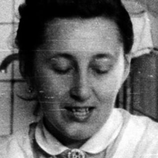 Nurse enjoying meal with wine indoors.