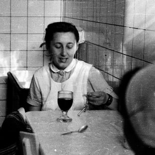 Nurse enjoying meal with wine indoors.