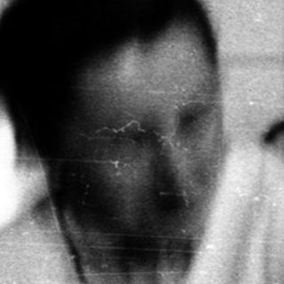 Blurred black-and-white photo of man in bathroom.