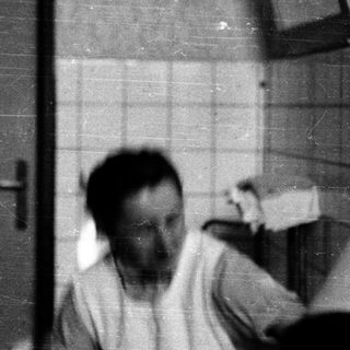 Blurred black-and-white photo of man in bathroom.