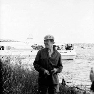 Old man in military cap by waterfront.