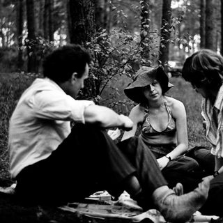 People picnicking and socializing in a forested area.