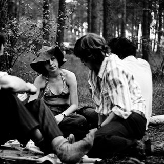 People picnicking and socializing in a forested area.