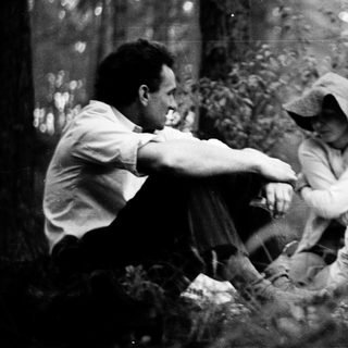 People gathered around a campfire in a forest.
