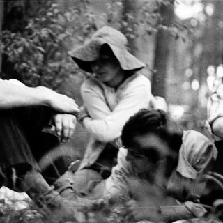 People gathered around a campfire in a forest.