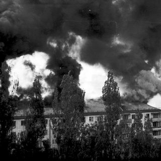 Smoke rising over residential buildings.