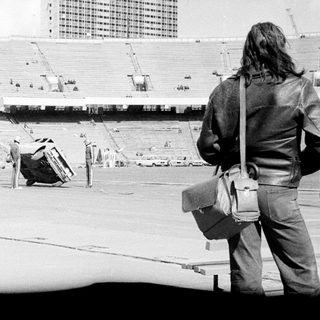 Empty stadium under construction with workers and equipment.