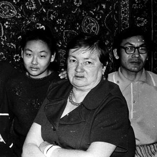 Group of five adults and two children posing indoors.